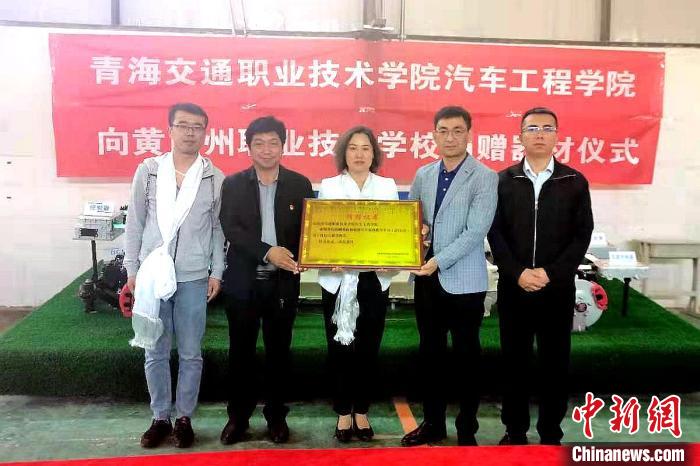 圖為李富香(中)代表學(xué)校為州縣技校捐贈(zèng)器材。(資料圖) 青海省教育廳供圖