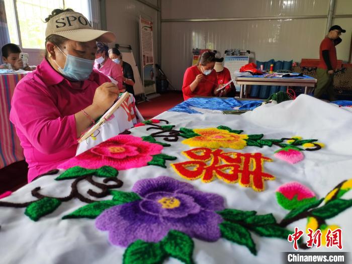圖為婦女制作青繡?！?zhí)砀?攝