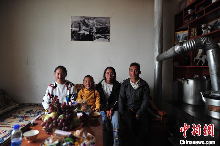 圖為8月12日，2018年7月從距那曲市色尼區(qū)城區(qū)那曲鎮(zhèn)90千米外的古露鎮(zhèn)當(dāng)桑村搬遷至城區(qū)的旦增(右一)與家人在80多平方米的新家合影(資料圖)?！垈?攝