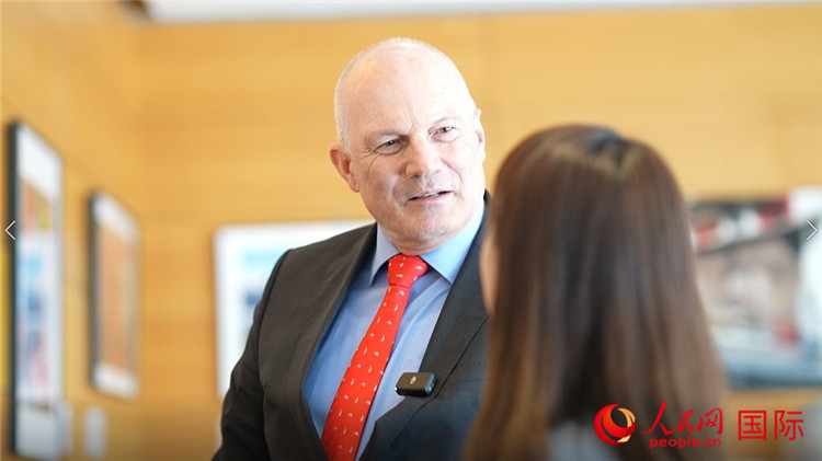 瑞士駐華大使白瑞誼介紹使館內(nèi)陳列的照片。人民網(wǎng) 彭昱凱攝