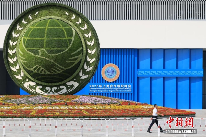 8月31日，天津，一名工作人員從2025年上海合作組織峰會主會場外的景觀花壇旁經(jīng)過。當(dāng)日，2025年上海合作組織峰會在天津舉行。<a target='_blank' href='/'><p  align=