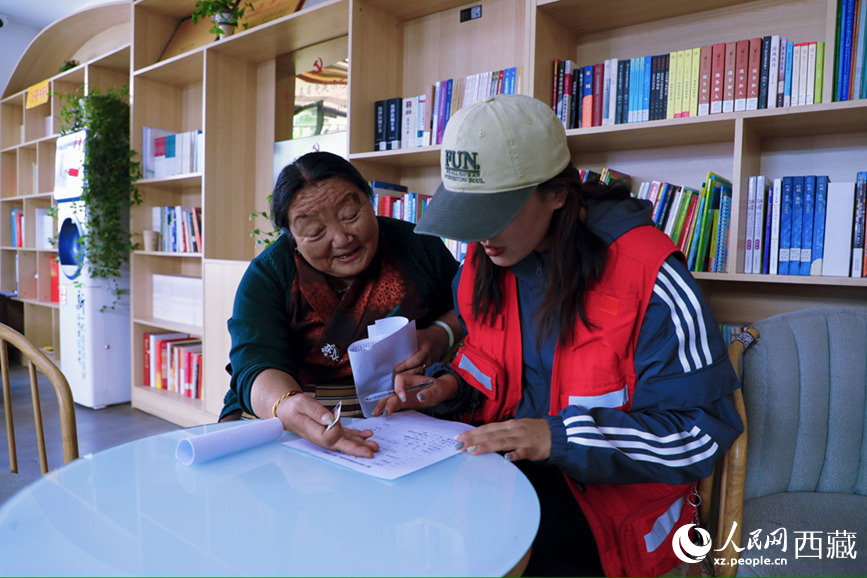 幸福社區(qū)的網(wǎng)格員協(xié)助老人填寫雙聯(lián)戶檔案表。人民網(wǎng)記者 次仁羅布攝