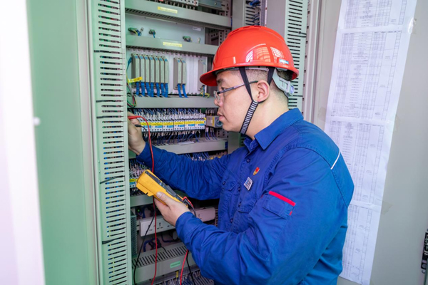 呂曉勇在保護(hù)盤柜前檢查二次回路接線情況。受訪者供圖