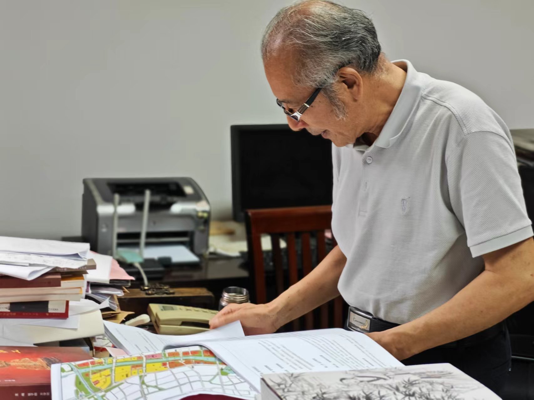 顧風(fēng)在辦公室翻閱資料。人民網(wǎng)記者 黃鈺攝