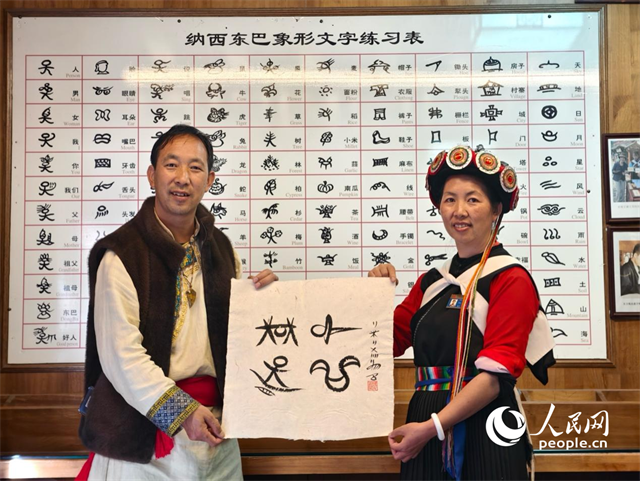 人民網(wǎng)“行進(jìn)中國”云南調(diào)研采訪團(tuán)走進(jìn)麗江，和閏元現(xiàn)場用東巴文寫下“行進(jìn)中國”。人民網(wǎng)記者 符皓攝