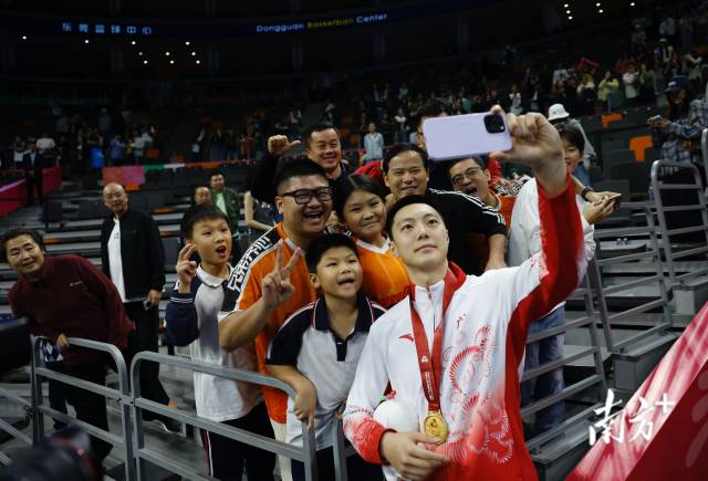 11月12日，十五運(yùn)會(huì)男籃成年組決賽，廣東隊(duì)獲得冠軍后，胡明軒與球迷們合影留念。張由瓊 攝