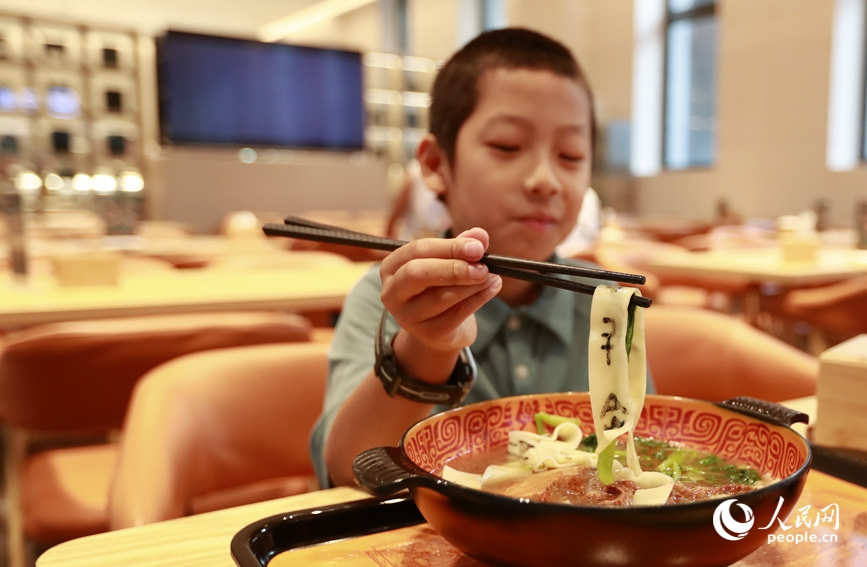 殷墟博物館推出的甲骨文面深受游客喜愛。人民網(wǎng)記者 慎志遠 攝