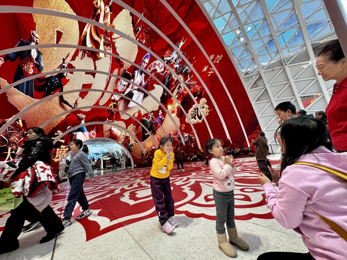 乙巳蛇年春節(jié)期間，影迷在《哪吒之魔童鬧海》巨幅海報前拍照打卡。