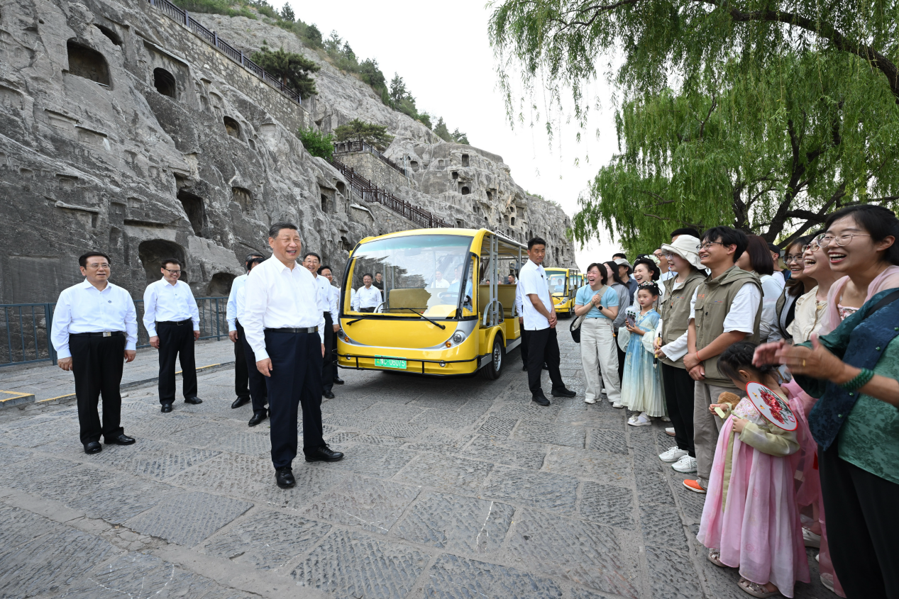 5月19日，習近平在洛陽龍門石窟考察時，同游客親切交流。