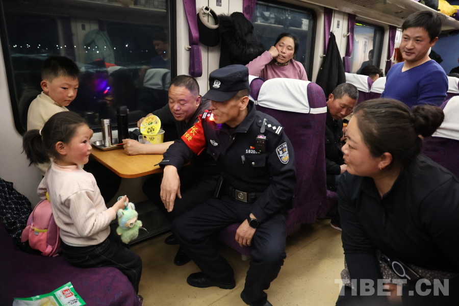 乘警長左紅彬在巡視車廂間隙，向攜帶兒童的旅客專門叮囑安全注意事項(xiàng)。.JPG