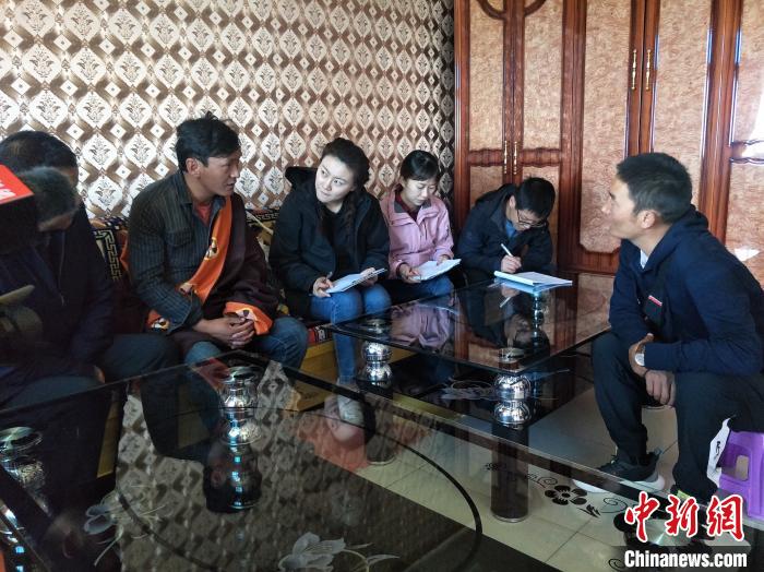 圖為調(diào)查組工作人員正在入戶調(diào)查。　祁增蓓 攝