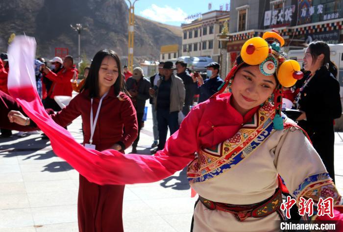 圖為中外記者向當(dāng)?shù)孛癖妼W(xué)習(xí)民族歌舞文化?！?zhí)砀?攝