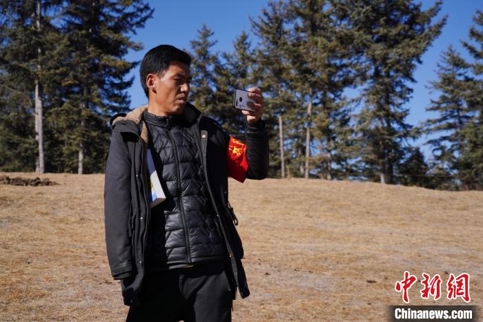 圖為桑杰加進行巡查并拍照記錄?！●R銘言 攝