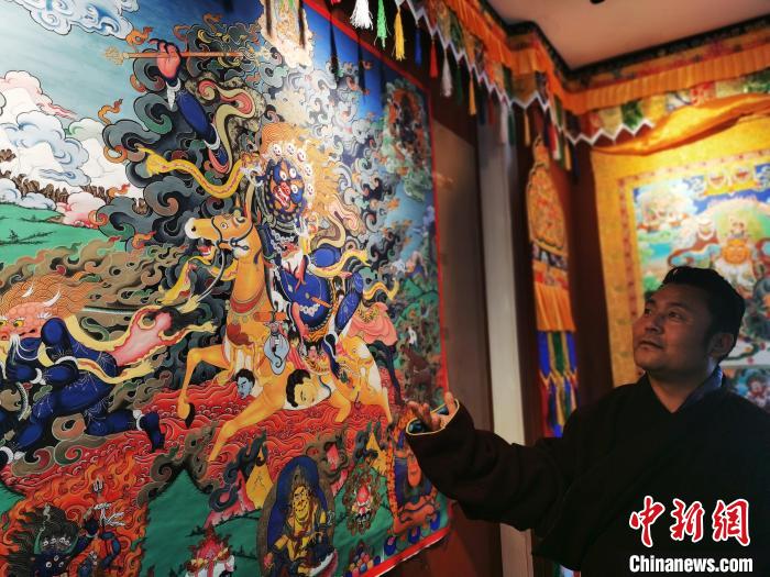 圖為久美尖措展示唐卡作品。　張?zhí)砀?攝