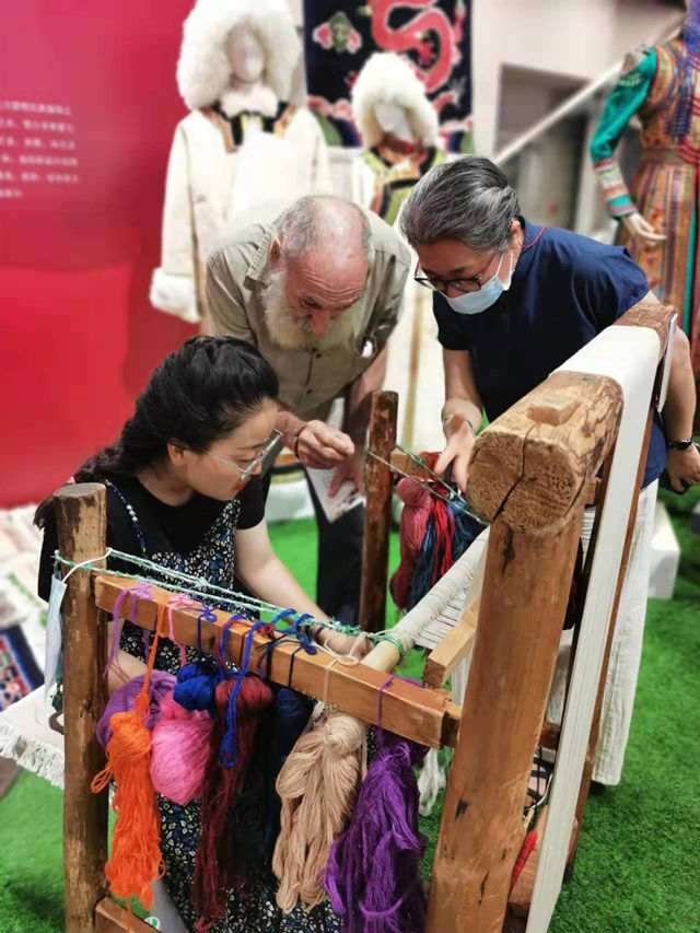 楊永良的學(xué)生在展會(huì)上向客商介紹加牙藏毯編織技藝。受訪(fǎng)者供圖