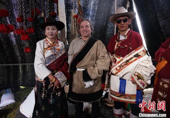 圖為一名外籍?dāng)z影師(中)身穿藏服和藏族民眾合影留念?！●R銘言 攝