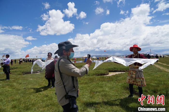 圖為一名外籍?dāng)z影師記錄當(dāng)?shù)夭刈鍤g迎儀式?！●R銘言 攝