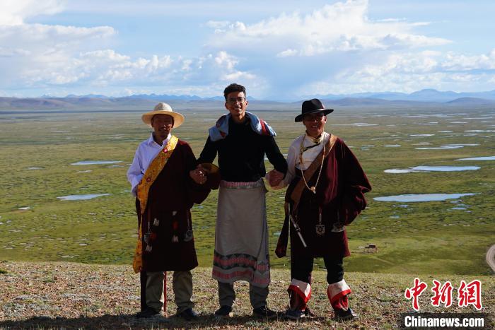 圖為一名留學(xué)生身穿自己國家的服飾和藏族民眾合影留念?！●R銘言 攝