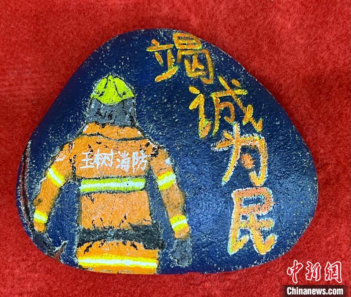 圖為玉樹消防指戰(zhàn)員創(chuàng)作的石頭畫作品《逆行在路上》?！O瑞祥 攝