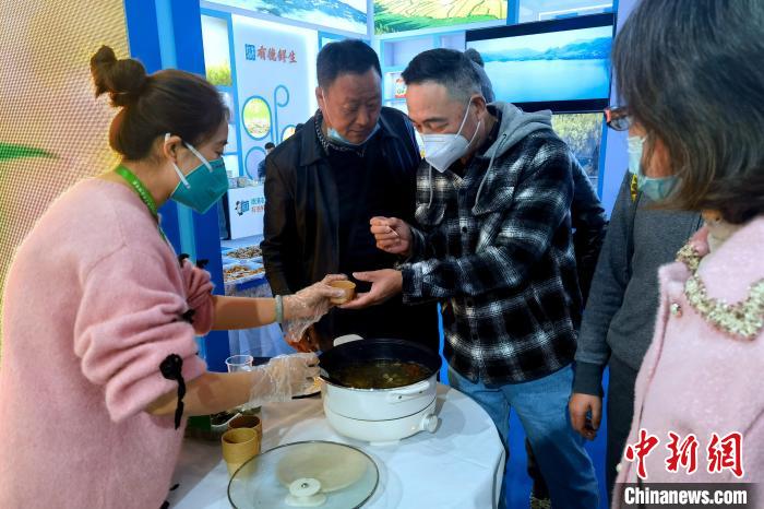 圖為杭州市民品嘗茶卡羊肉。　李雋 攝