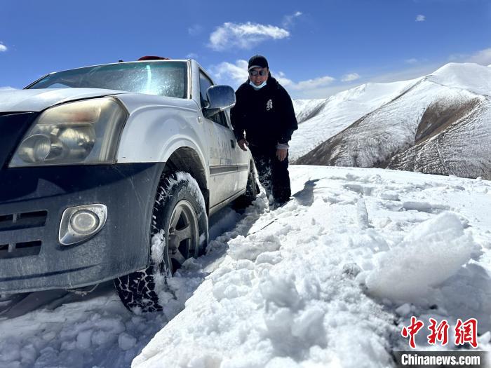 圖為生態(tài)管護人員準備在雪地推車?！《“瓦_杰 攝