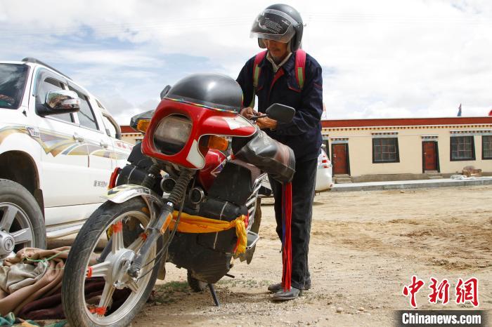 圖為白瑪準備騎摩托車巡湖。　趙朗 攝