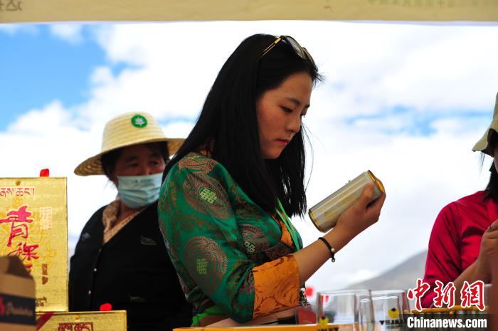 圖為拉薩市民在特色農(nóng)畜產(chǎn)品展示展銷會上選購商品?！垈?攝