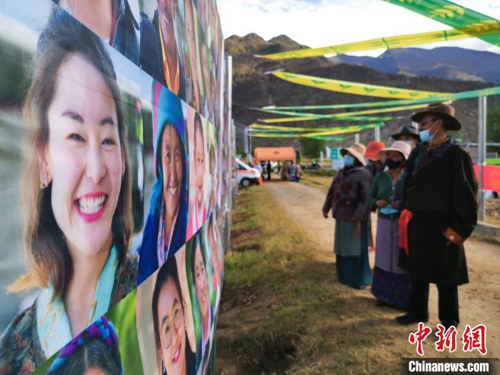 圖為當?shù)孛癖娫谟^看展板上的笑臉。　張偉 攝