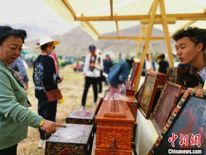 圖為拉薩市民在特色農(nóng)畜產(chǎn)品展示展銷會上選購商品?！垈?攝