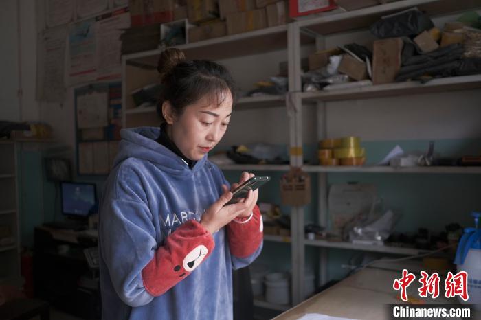 正在快遞站點(diǎn)內(nèi)忙碌的楊莉春。　何蓬磊 攝