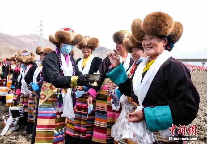 資料圖：西藏自治區(qū)拉薩市曲水縣才納鄉(xiāng)協(xié)榮村參加春耕儀式的村民互敬青稞酒。按照傳統(tǒng)，當(dāng)?shù)卮迕裆碇?jié)日盛裝，舉行隆重的儀式，祈福一年的豐收。<a target='_blank' ><p  align=