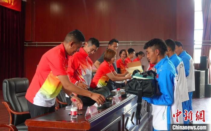 圖為世界冠軍們?yōu)槲鞑刈灾螀^(qū)體校的學(xué)生們送上暖心物資。　冉文娟 攝