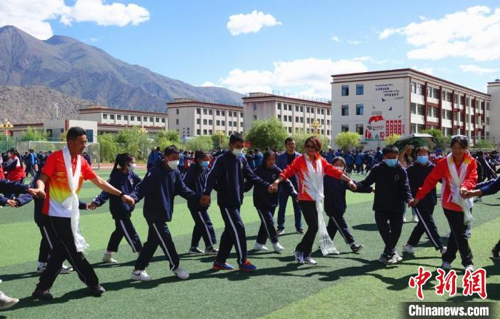 圖為世界冠軍與拉薩阿里地區(qū)高級(jí)中學(xué)學(xué)生一起跳鍋莊?！∪轿木?攝