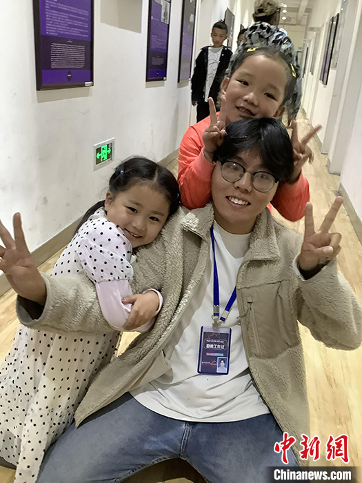 “Z世代”旦真旺加認(rèn)為，拉薩是一座開(kāi)放與包容的城市，記憶中的拉薩是彩色的。2021年，旦真旺加從浙江大學(xué)漢語(yǔ)言文學(xué)專(zhuān)業(yè)畢業(yè)后，他選擇回到拉薩，成為一名漢語(yǔ)文實(shí)習(xí)助教。圖為8月4日，旦真旺加在課間陪學(xué)生玩耍。 <a target='_blank' ><p  align=