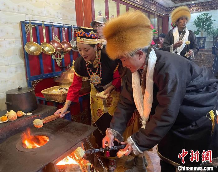 圖為人們?cè)诨鹕峡竟?jié)日美食“結(jié)達(dá)”?！∪轿木?攝