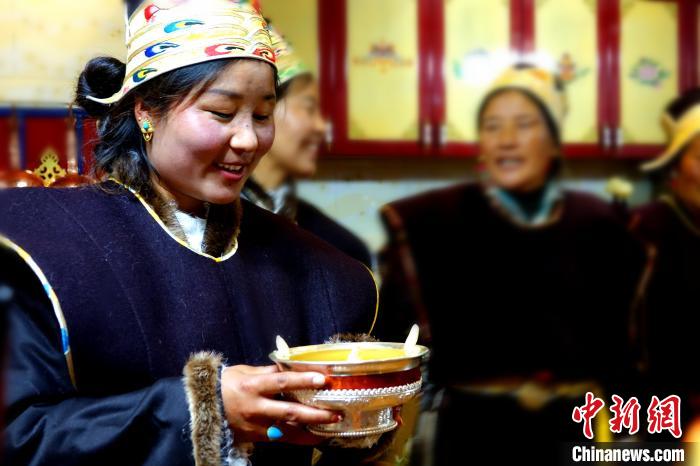 圖為藏族姑娘向客人敬酒?！∪轿木?攝