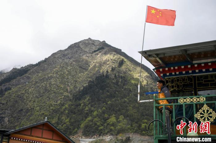 村民站在樓房上觀望?！钊A峰 攝