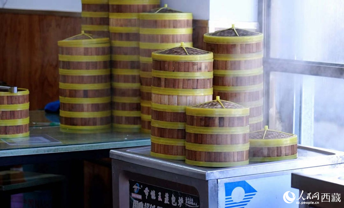 電蒸箱上擺滿了多屜熱氣騰騰的包子。人民網(wǎng) 次仁羅布攝
