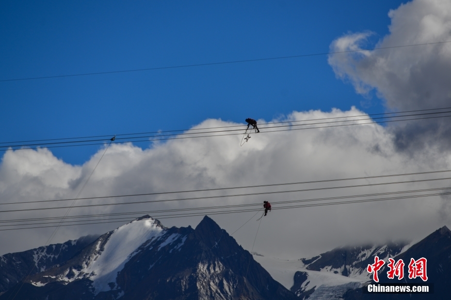 資料圖為2020年6月23日，西藏阿里聯(lián)網(wǎng)工程施工人員在日喀則希夏邦馬雪山附近進行走線作業(yè)，安裝絕緣設(shè)備。 <a target='_blank' href='/'><p  align=