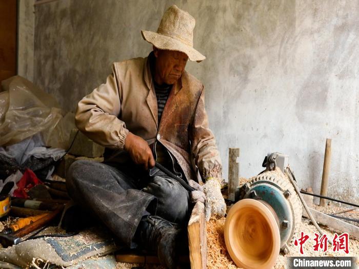 圖為手工藝人正在制作木碗?！?鄧海平 攝