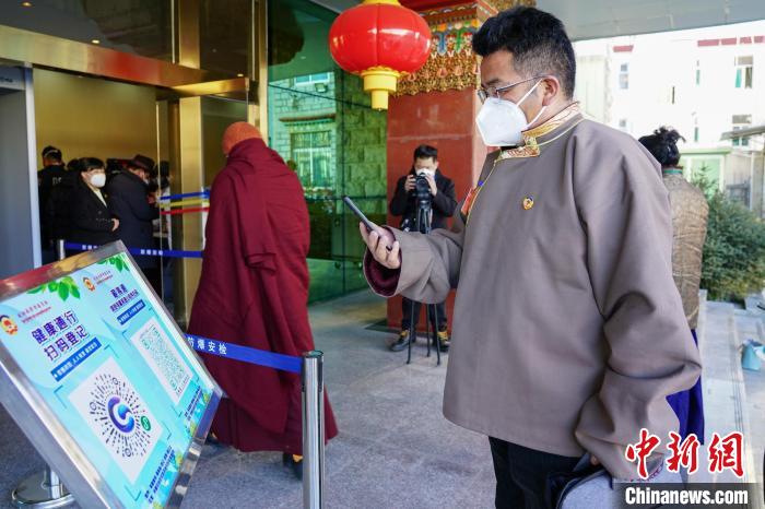 圖為政協(xié)委員掃場所碼進(jìn)入會(huì)場?！〗w波 攝