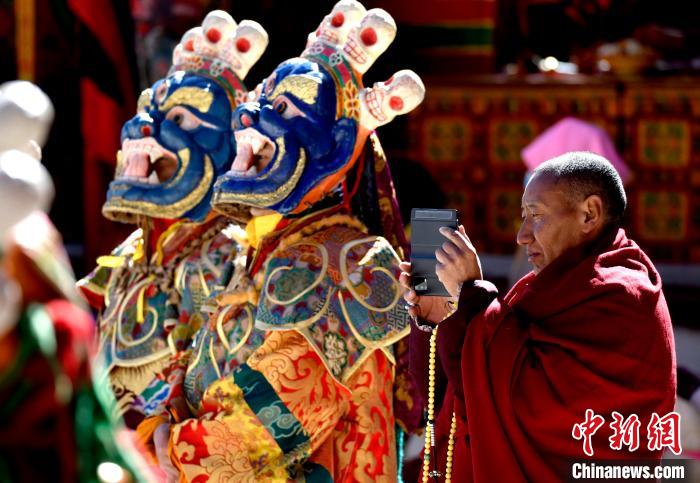 2月19日，正在拍攝跳神活動(dòng)的僧人。　李林 攝