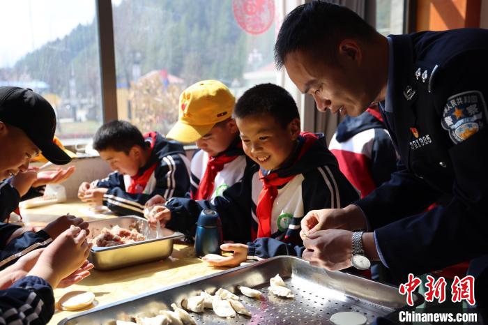圖為亞東邊檢站民警與駐地小學生其樂融融包餃子?！『?攝