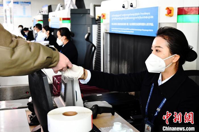 圖為機場工作人員為旅客辦理行李托運。　周航 攝