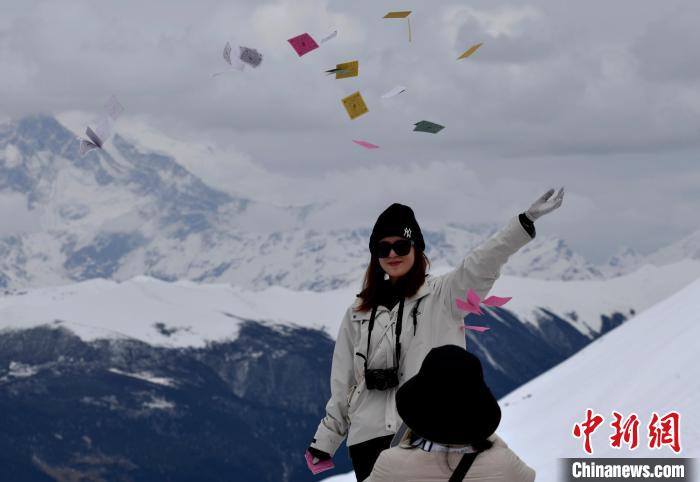 圖為5月14日，游客在西藏林芝色季拉山觀景臺拋灑“隆達”(風馬旗，藏族民眾的一種祈福方式)?！±盍?攝