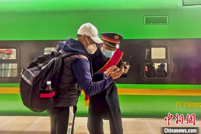 圖為日喀則火車站工作人員服務(wù)乘客?！《飞降?攝