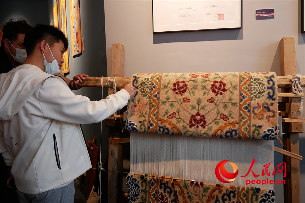 觀眾正在觀賞展出的藏毯。人民網(wǎng) 韋衍行攝
