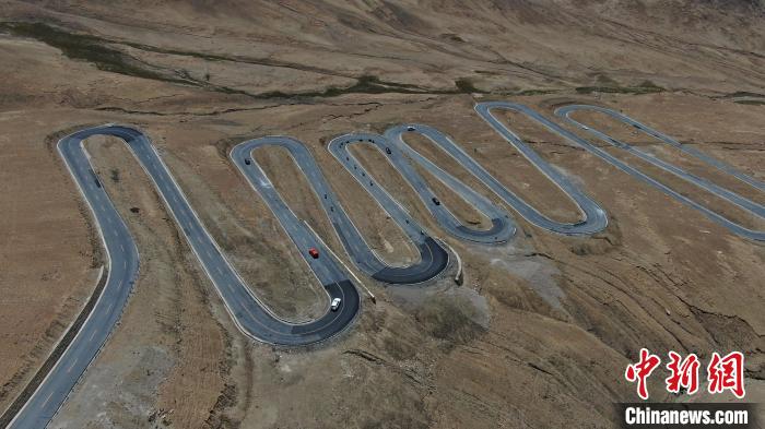 圖為騎手前往珠峰大本營途經(jīng)108道拐?！∮文恋厍蚬﹫D