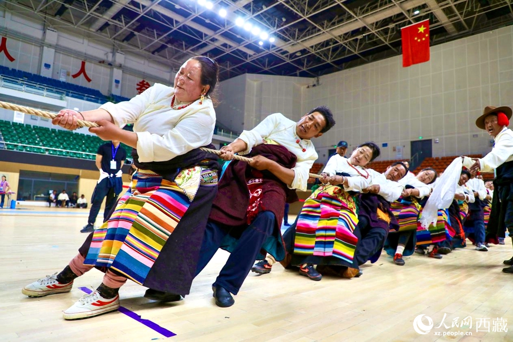 身著民族服裝的農(nóng)牧民選手在拔河比賽現(xiàn)場。