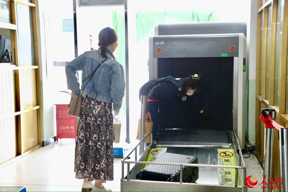 車站工作人員幫旅客提取行李。人民網(wǎng)記者 次仁羅布攝